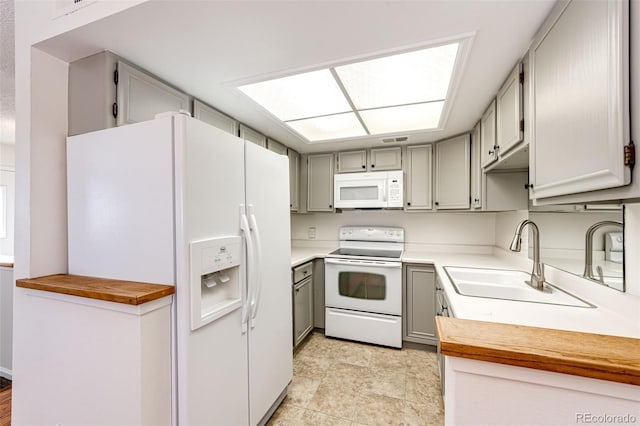 kitchen with sink, white appliances, wooden counters, and gray cabinets