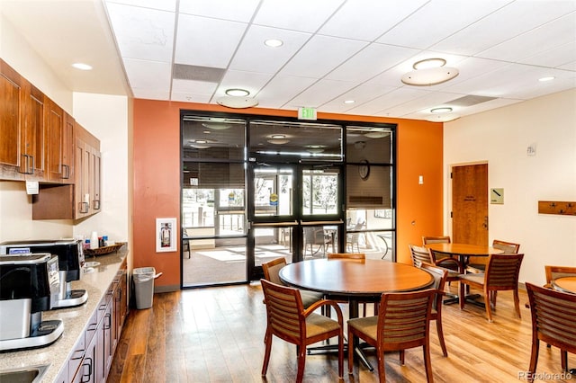 dining area with a paneled ceiling and hardwood / wood-style flooring