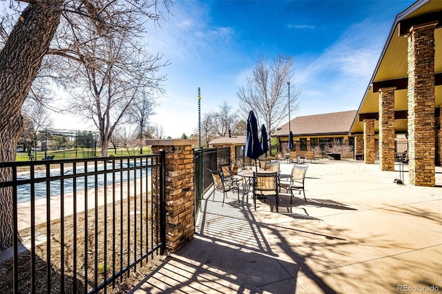 view of gate featuring a pool and a patio