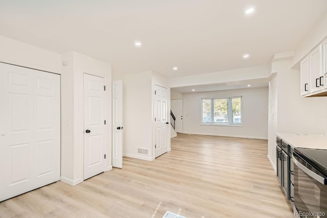 interior space with light hardwood / wood-style flooring, white cabinetry, and electric stove