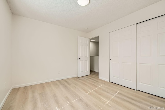 unfurnished bedroom featuring a textured ceiling and a closet