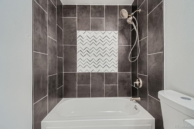 bathroom with tiled shower / bath combo and toilet