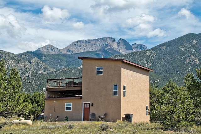 view of side of property with a mountain view and a balcony