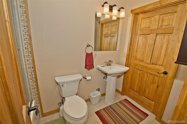 bathroom with toilet and tile patterned floors