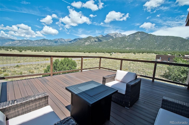 wooden deck featuring a mountain view and an outdoor hangout area