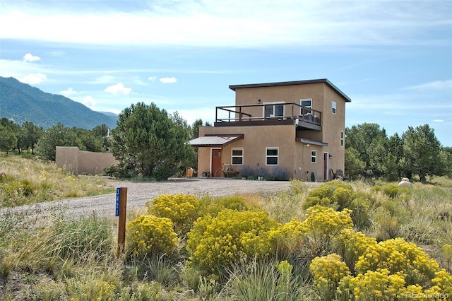 3421 Camino Del Rey, Crestone, CO 81131 - view of front of home with a balcony, stucco siding, and a mountain view