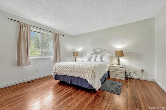 19140 E Milan Cir, Aurora, CO 80013 - bedroom with baseboards, a textured ceiling, visible vents, and wood finished floors