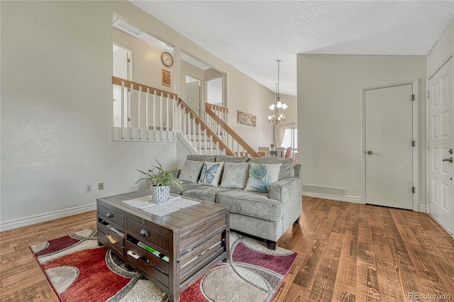 19140 E Milan Cir, Aurora, CO 80013 - living room featuring an inviting chandelier, vaulted ceiling, stairs, and wood finished floors