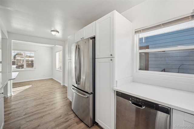 kitchen with white cabinetry, stainless steel appliances, and light hardwood / wood-style floors