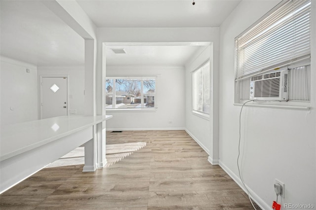 foyer featuring cooling unit, a healthy amount of sunlight, and light hardwood / wood-style flooring