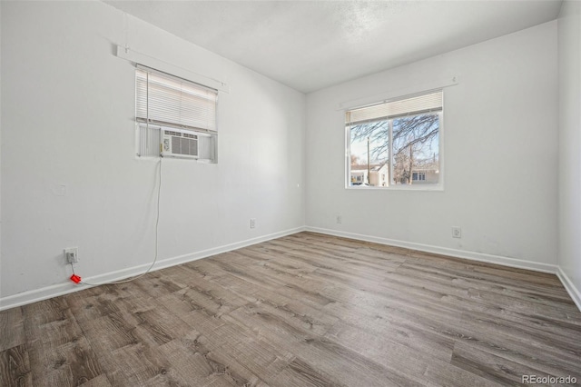 empty room with cooling unit and light hardwood / wood-style floors