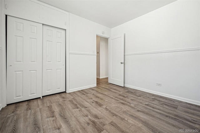 unfurnished bedroom with a closet and light wood-type flooring