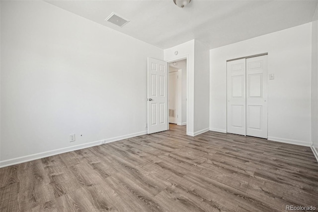 unfurnished bedroom featuring a closet and light hardwood / wood-style flooring