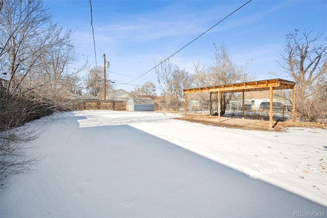 yard covered in snow with a storage shed