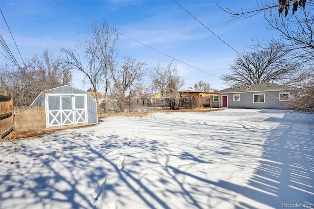 snowy yard featuring a shed