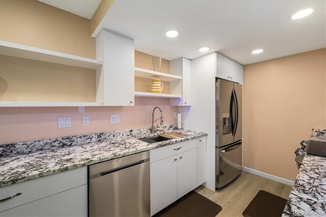 3482 S Eagle St Unit 102, Aurora, CO 80014 - kitchen with open shelves, appliances with stainless steel finishes, a sink, light wood finished floors, and white cabinetry