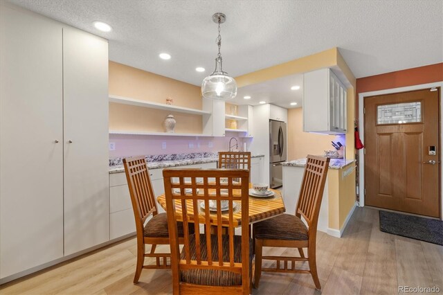 3482 S Eagle St Unit 102, Aurora, CO 80014 - dining room with light wood-type flooring, a textured ceiling, and recessed lighting