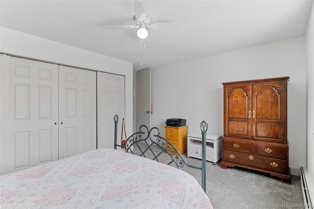 bedroom with light carpet, a textured ceiling, baseboard heating, ceiling fan, and a closet