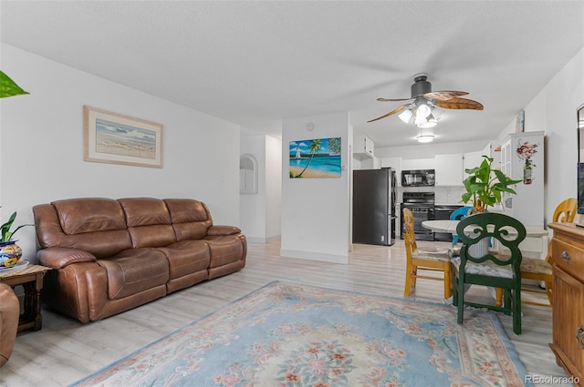 living area with light wood finished floors and a ceiling fan