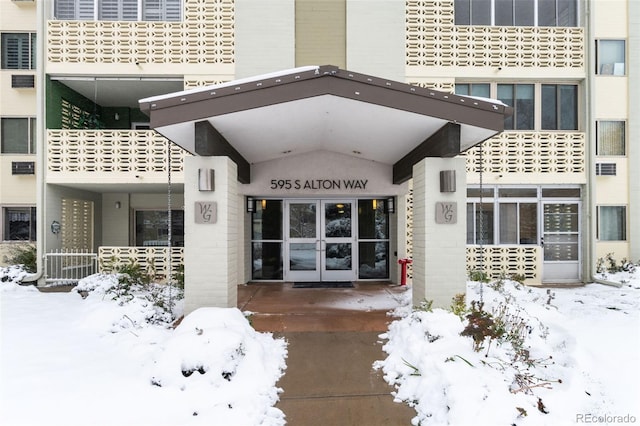 snow covered property entrance with french doors