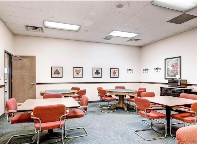 carpeted dining space featuring a drop ceiling and visible vents
