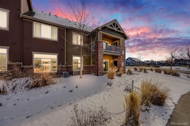 snow covered house featuring a balcony