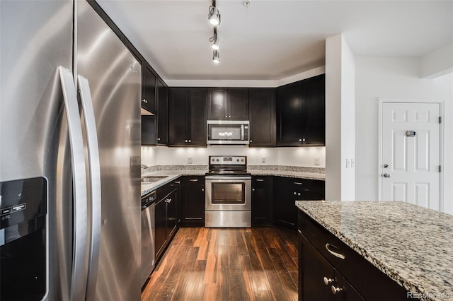 kitchen featuring light stone countertops, appliances with stainless steel finishes, and dark wood-type flooring