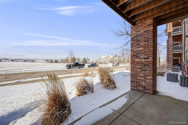 snow covered patio featuring central AC