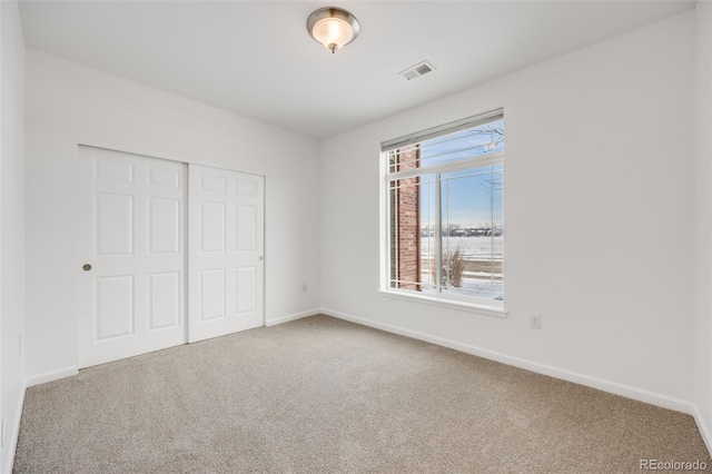 unfurnished bedroom featuring carpet flooring and a closet