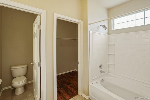 15594 E 97th Ave, Commerce City, CO 80022 - bathroom with tile patterned flooring, bathing tub / shower combination, toilet, baseboards, and a spacious closet