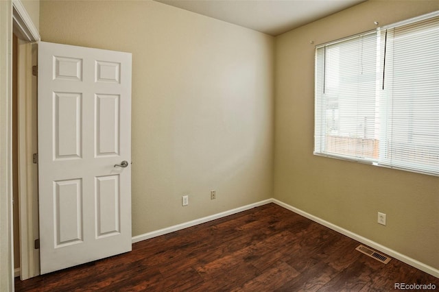 15594 E 97th Ave, Commerce City, CO 80022 - spare room featuring baseboards, dark wood-type flooring, and visible vents