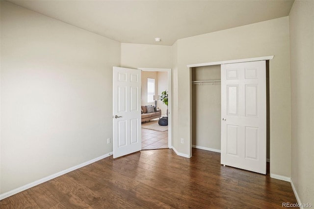15594 E 97th Ave, Commerce City, CO 80022 - unfurnished bedroom with baseboards, a closet, and dark wood-type flooring