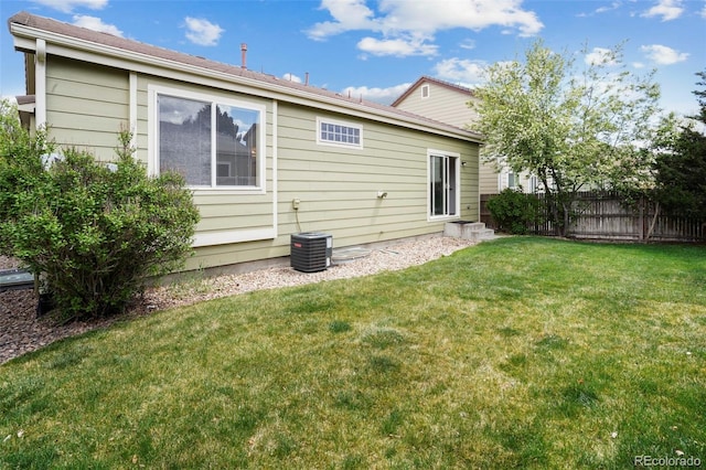 15594 E 97th Ave, Commerce City, CO 80022 - back of house featuring a lawn, fence, and cooling unit