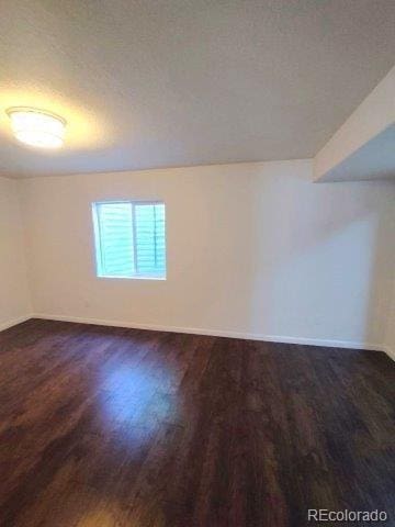 15594 E 97th Ave, Commerce City, CO 80022 - unfurnished room with dark wood finished floors and baseboards