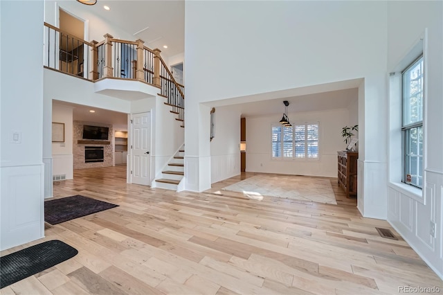 foyer entrance featuring a high ceiling and light wood-type flooring