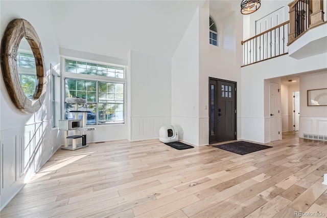 foyer featuring light hardwood / wood-style flooring and a towering ceiling