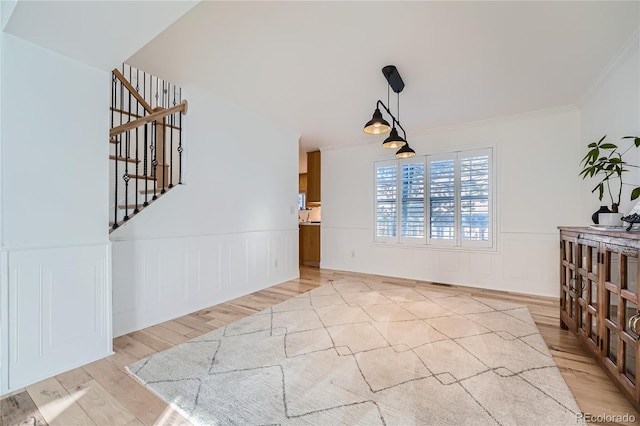 dining space with ornamental molding and light wood-type flooring