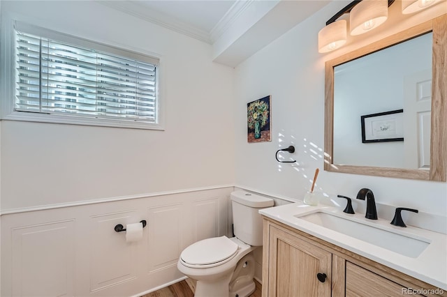 bathroom featuring toilet, ornamental molding, hardwood / wood-style flooring, and vanity