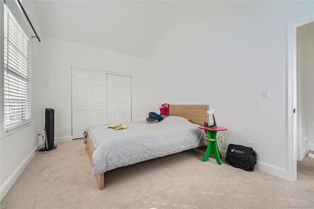 carpeted bedroom featuring a closet and lofted ceiling