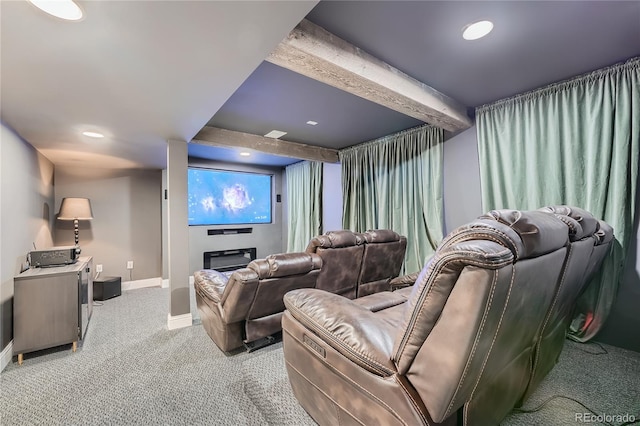 carpeted home theater featuring beamed ceiling