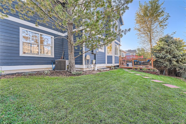 view of yard with central AC and a deck