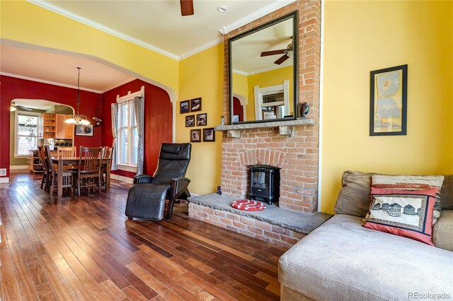 living area with wood-type flooring, arched walkways, ceiling fan with notable chandelier, and crown molding