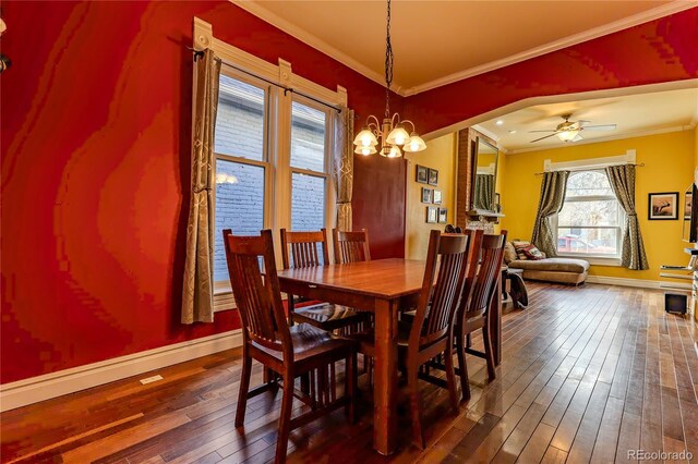 dining area with baseboards, ornamental molding, wood-type flooring, and ceiling fan with notable chandelier