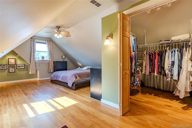 bedroom featuring visible vents, a closet, lofted ceiling, baseboards, and light wood-style floors