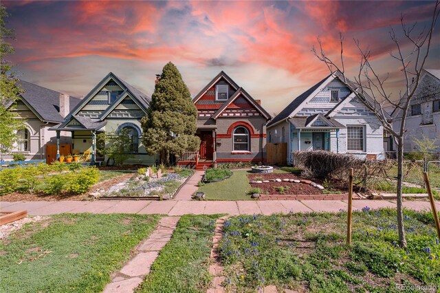 craftsman-style house with brick siding, fence, and a front yard