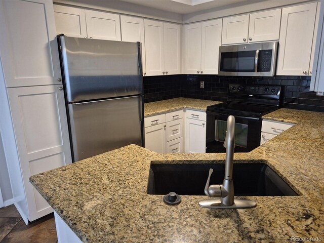 2238 S Nile Ct, Aurora, CO 80014 - kitchen featuring stainless steel appliances, light stone counters, white cabinetry, and decorative backsplash