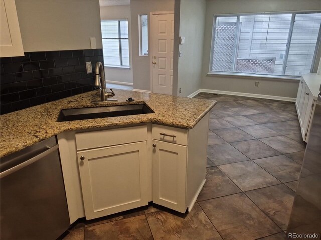 2238 S Nile Ct, Aurora, CO 80014 - kitchen featuring stainless steel dishwasher, a sink, white cabinets, and a peninsula