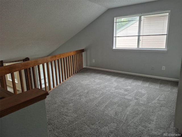 2238 S Nile Ct, Aurora, CO 80014 - bonus room featuring a textured ceiling, lofted ceiling, carpet flooring, and baseboards