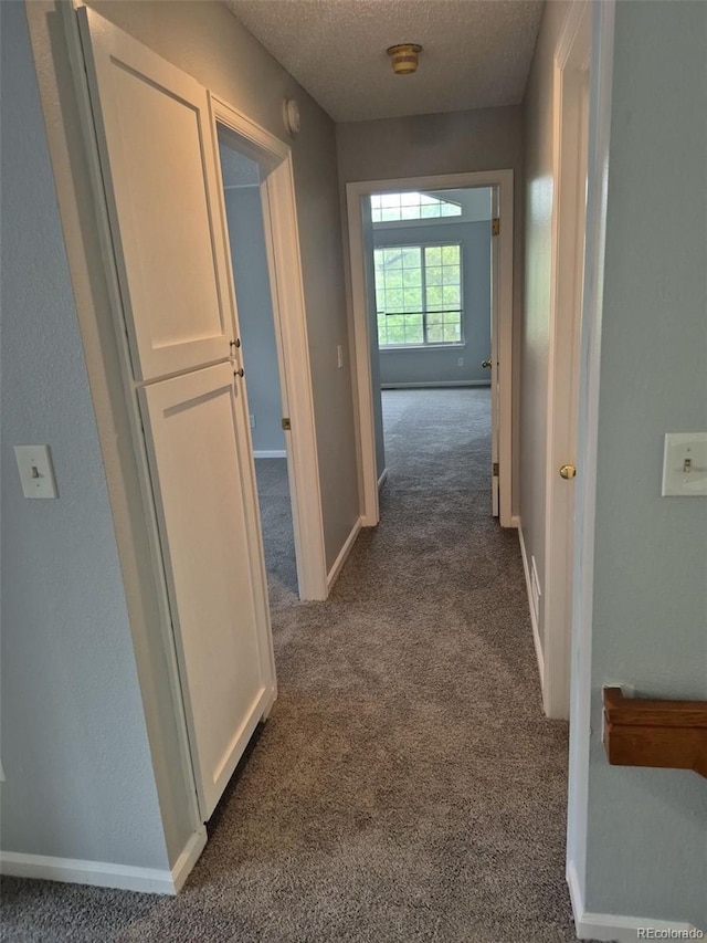 2238 S Nile Ct, Aurora, CO 80014 - corridor featuring dark colored carpet, a textured ceiling, and baseboards