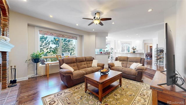 living room featuring ceiling fan, a fireplace, and hardwood / wood-style flooring